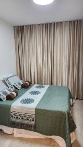 um quarto com uma cama e uma janela com cortinas em Studio Encantador a Beira Mar e Próximo do Centro de Convenções em Salvador