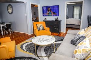 a living room with a couch and chairs and a tv at Cozy 2BR Apartment, Balcony with City Skyline View, Mardi Gras Park, Free Parking, Wi-Fi in Mobile