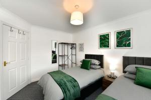 - une chambre avec 2 lits verts et blancs dans l'établissement The Coach House, à Clydach
