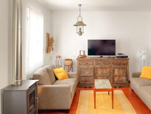 uma sala de estar com 2 sofás e uma televisão de ecrã plano em WelcomeBuddy - Casa da Praia - Moinhos Beach em Porto Formoso