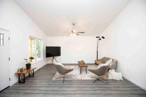 a white living room with chairs and a tv at Farmville Modern Farmhouse in Farmville