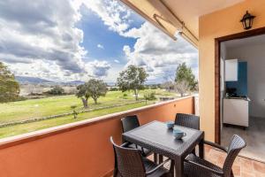 a balcony with a table and chairs and a large window at Baia Turchese Olbia in Olbia