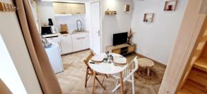 - une cuisine avec une table et des chaises dans la chambre dans l'établissement LaMaisonnette 500m plage Juno Beach, à Bernières-sur-Mer