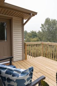 Una terraza de madera con una silla en un porche. en Brand New 3 Bedroom!, en Loves Park