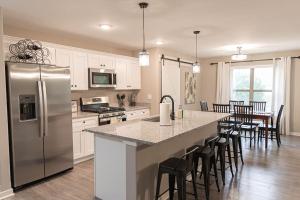 Una cocina con refrigerador y una mesa con sillas. en Brand New 3 Bedroom!, en Loves Park