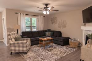 Una sala de estar con un sofá negro y una silla. en Brand New 3 Bedroom!, en Loves Park