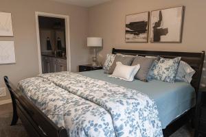 Un dormitorio con una cama grande con sábanas y almohadas azules. en Brand New 3 Bedroom!, en Loves Park