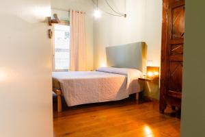 een kleine slaapkamer met een bed en een raam bij La sosta verde by HAPPYHOSTORINO in Turijn