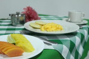 two plates of food on a green and white table at Hotel Vesta Boutique in Neiva