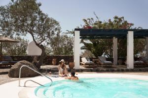 una mujer y un niño en una piscina en Vedema, a Luxury Collection Resort, Santorini, en Megalokori