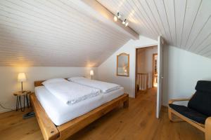 a bedroom with a bed and a couch in a room at Undereggli in Nesslau