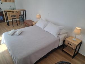 een slaapkamer met een bed met witte lakens en kussens bij Venue Studios in Lima