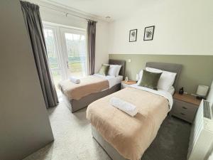 a hotel room with two beds and a window at Luxury Canal-side Apartment, Hemel Hempstead, Free parking, Perfect for Contractors in Hemel Hempstead