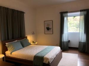 a bedroom with a bed and a large window at Casa do Monte – Sea sight in Lagoa +28 photos