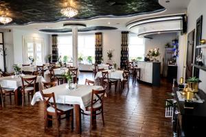 a dining room with white tables and chairs at Cynamon in Nowy Sącz