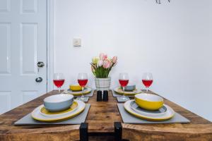 a table with plates and glasses of red wine at Cotton St House - Sleeping 7 in Burnley