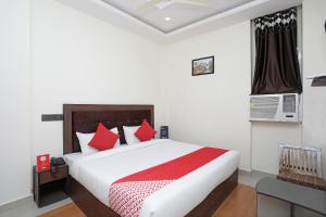 a bedroom with a large bed with red pillows at Collection O Hotel Divine Ganges in Haridwār