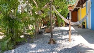 伊塔帕里卡的住宿－亞卡薩多維澤霍旅館，棕榈树建筑前的吊床