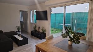 a living room with a black couch and a large window at Joli appart à 10mn de paris in Bezons