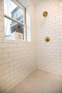 a white tiled shower with a window in a bathroom at Farmville Modern Loft in Farmville