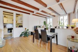 cocina y comedor con mesa y sillas en Center of Paris apartment for 4 people !, en París