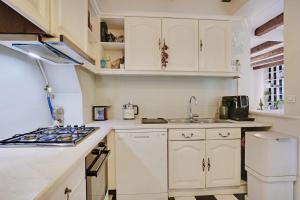 una cocina con armarios blancos y fregadero en Center of Paris apartment for 4 people !, en París