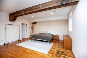 Schlafzimmer mit einem Bett und Holzboden in der Unterkunft Farmville Modern Loft in Farmville