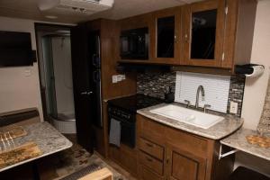 a kitchen with a sink and a stove at Quiet Cozy Camper in Niceville