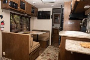 an rv kitchen with wooden cabinets and a counter top at Quiet Cozy Camper in Niceville