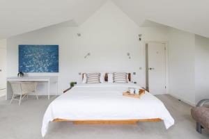 um quarto branco com uma cama grande e uma secretária em Secluded barn style home with hot tub - sleeps 12 em Birdham