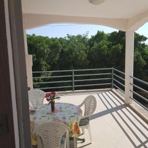 eine Terrasse mit einem Tisch und Stühlen auf dem Balkon in der Unterkunft Apartments Nenadić in Utjeha