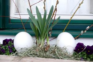 three eggs in a nest with a plant at Gourmet-Hotel Grünwald in Leogang