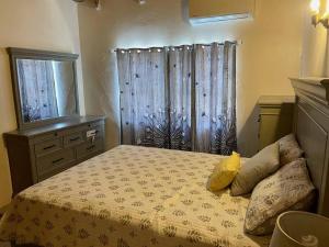 ein Schlafzimmer mit einem Bett, einer Kommode und einem Fenster in der Unterkunft Fruit Tree Castle in Kingshill