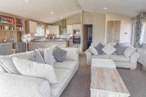 a living room with two couches and a table at Rowan a welcoming countryside lodge in Ryde