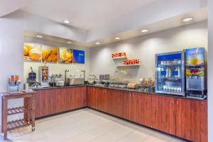 a fast food restaurant with a counter and a refrigerator at Comfort Suites Whitsett - Greensboro East in Whitsett