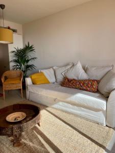 ein Wohnzimmer mit einem weißen Sofa und einem Tisch in der Unterkunft Casa Alba in San Pol de Mar