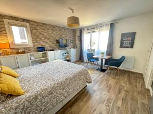 1 dormitorio con 1 cama y 1 mesa con sillas en Studio Centre Plage parking gratuit, en Collioure