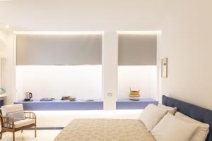 - une chambre avec un lit, une chaise et des fenêtres dans l'établissement Gheba Suites, à Sorrente