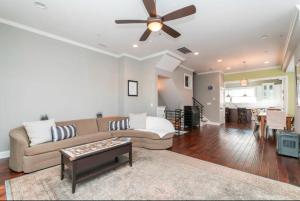 a living room with a couch and a ceiling fan at Huge 4 Bdrm - Roof Deck - Parking - Soak Tub! in Philadelphia