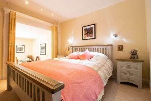 a bedroom with a large bed with pink pillows at Riverside in Knaresborough