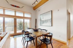 a dining room with a wooden table and chairs at Modern Mountain Magic in Eagle