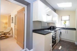 a kitchen with white cabinets and a sink at Riverside in Knaresborough