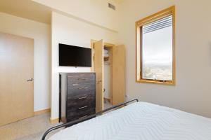 a bedroom with a bed and a flat screen tv at Modern Mountain Magic in Eagle