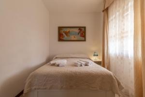 1 dormitorio con 1 cama con 2 toallas en Baia Turchese Olbia, en Olbia