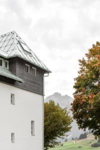 un edificio bianco con un tetto nero e due alberi di Lermooser a Lermoos