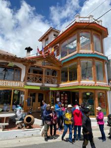 a group of people standing outside of a building at Hostería Chukirawa in Quilotoa