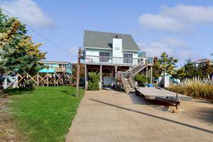 a house with a deck and a bench on a sidewalk at AVHC41 Outrigger Cottage on Hatteras Island in Avon