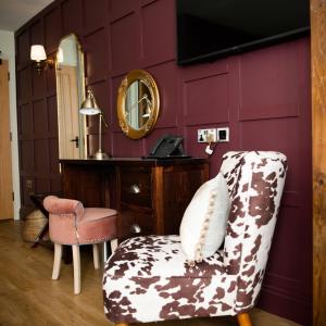 a living room with a chair and a mirror at The Duke on The Test in Romsey