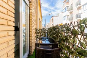 una silla de mimbre sentada junto a un edificio en Enjoy Valencia: Deluxe Apartment with Terrace, en Valencia