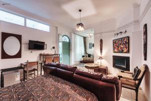 a living room with a leather couch and a fireplace at Ryad A&B Sarai in Chefchaouen